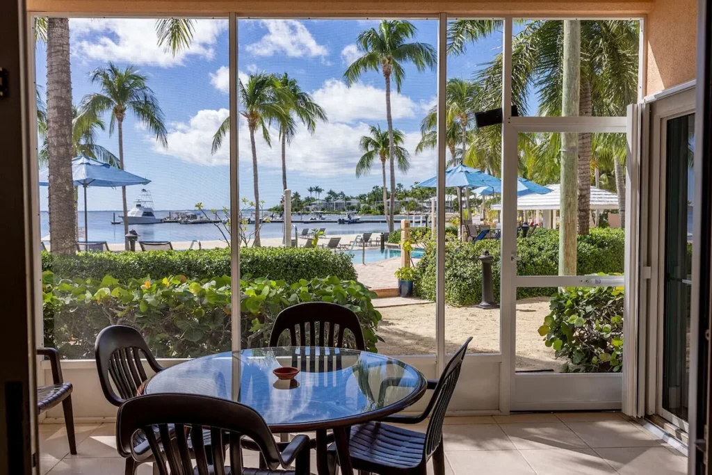 The screened porch at B13, looking out toward the palms, pool and beach